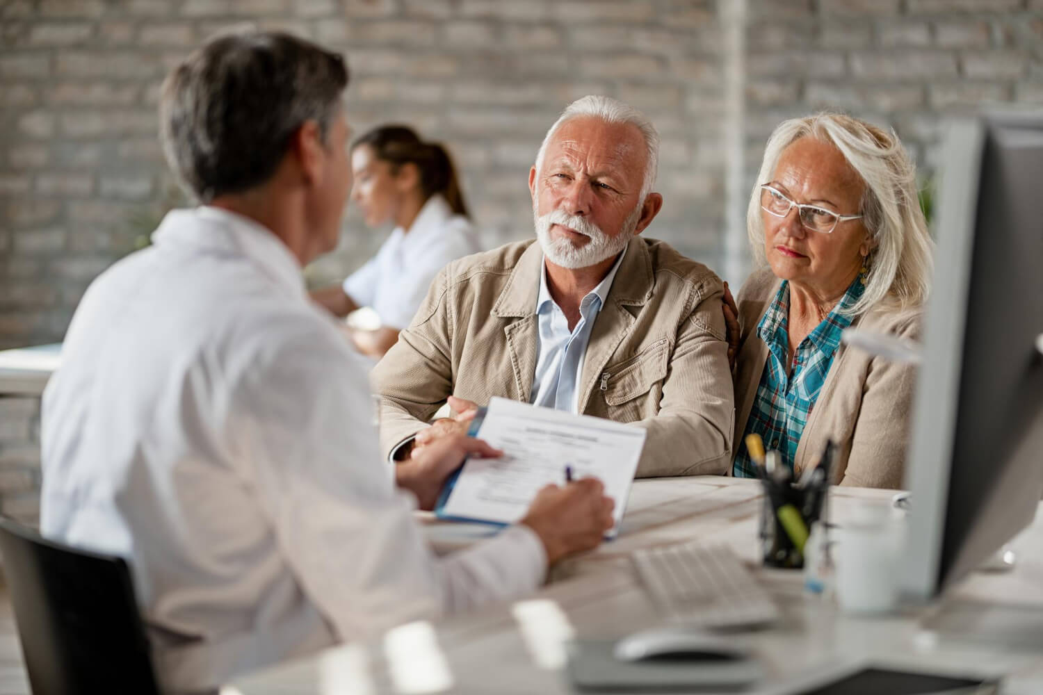 senior-couple-consulting-with-healthcare-worker-about-their-insurance-policy-while-having-meeting-clinic