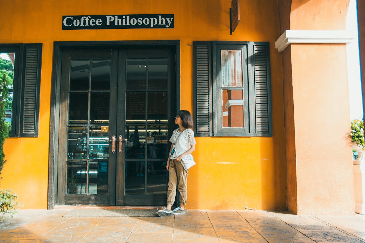 an Asian woman standing in front of a coffee shop