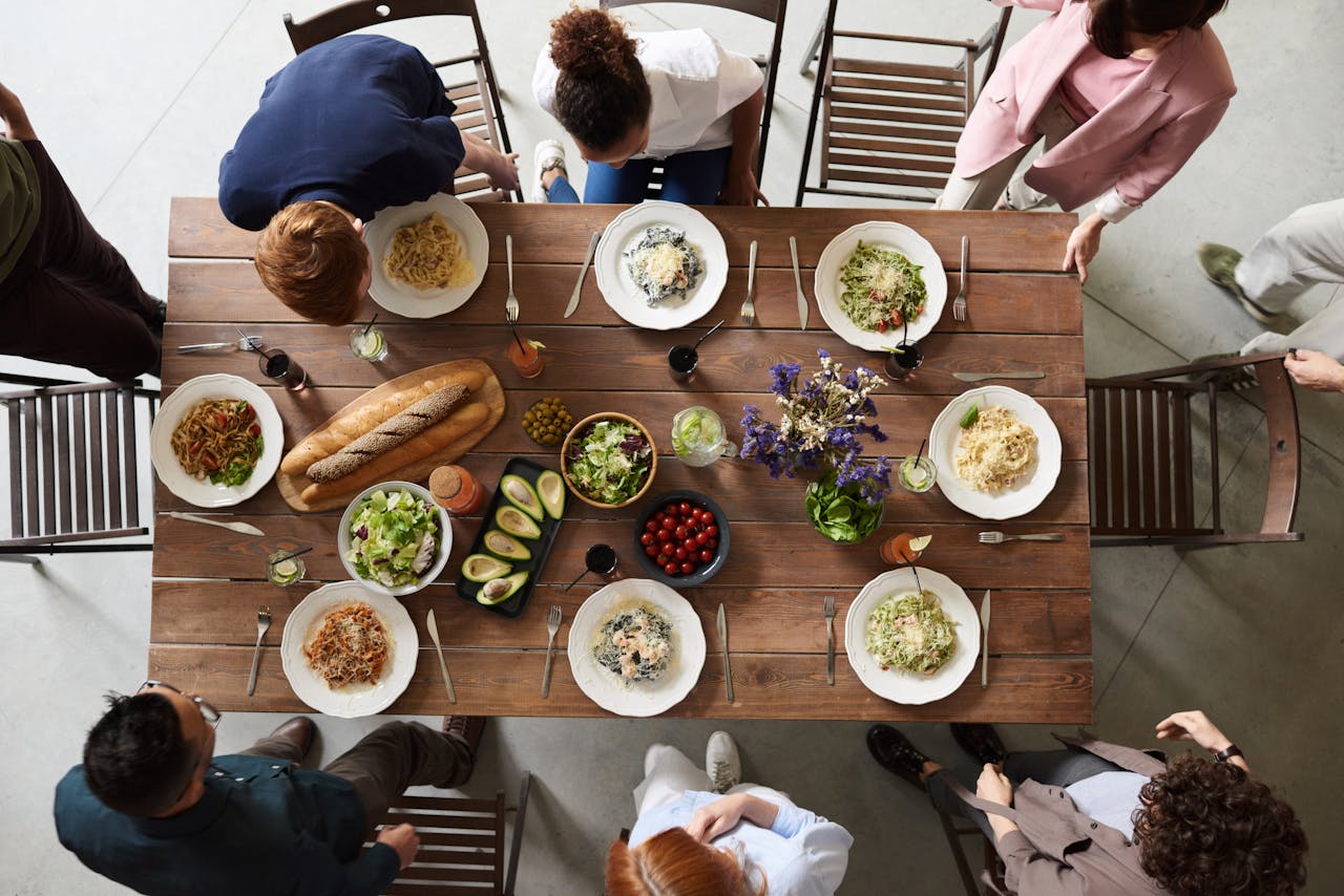 Group of people about to sit down at a table to have a meal